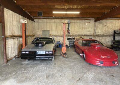 Two cars parked in a garage with a lift, ready for maintenance and repairs.