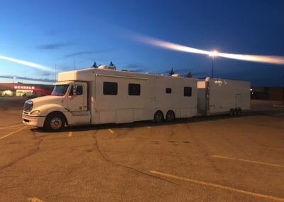 Large RV with white and black exterior on paved lot.