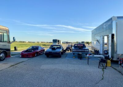 A parked car and truck next to a trailer.