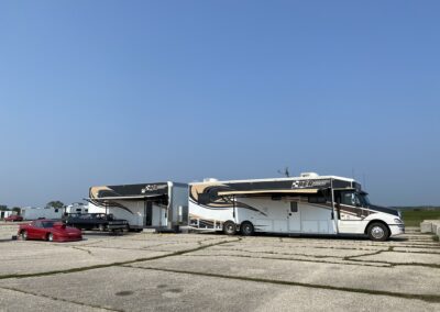 A white and black RV parked on a paved lo