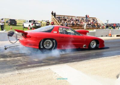 A red car speeding on a drag strip, showcasing its power and agility in a thrilling race.